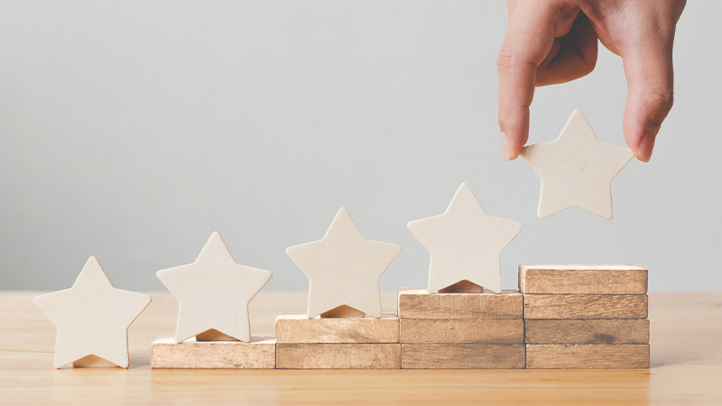 Hand putting wooden five star shapes on table. 